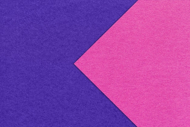 Texture of navy blue paper background half two colors with purple arrow macro Structure of craft indigo cardboard