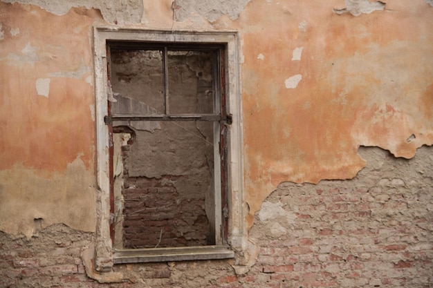 Texture of an old ragged wall background of old bricks and cracks in plaster yellow and brown tones