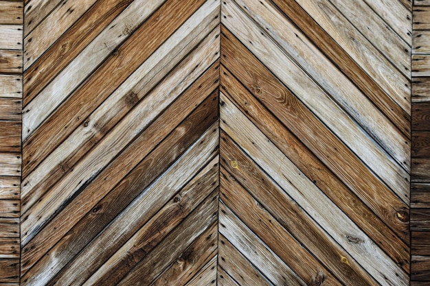 Texture old shabby diagonal wooden planks Fence farm gate Background of old boards faded in sun