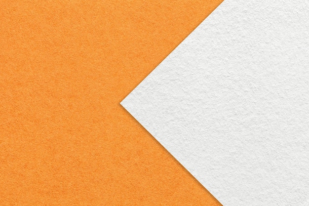 Texture of orange paper background half two colors with white arrow macro Structure of dense craft cardboard Felt abstract backdrop closeup