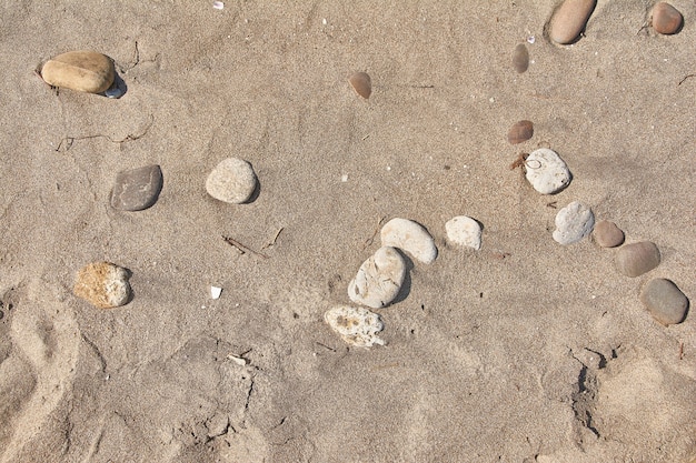 Texture of sand leveled by the wind with some pebbles