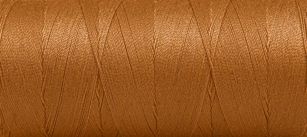 Texture of threads in a spool of brown color on a white background