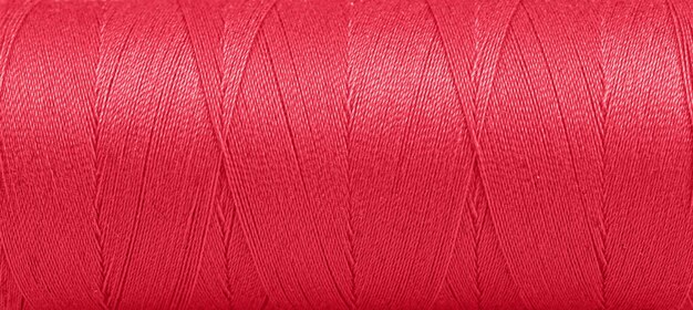 Texture of threads in a spool of red color on a white background