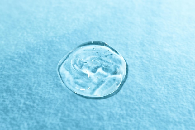 Texture of a transparent color cosmetic product on a blue background