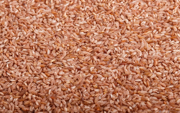 Texture of unpolished brown rice background. Side view, close up.