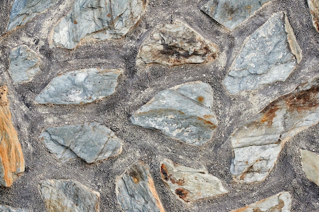 Texture of a wall with large stones embedded in cement