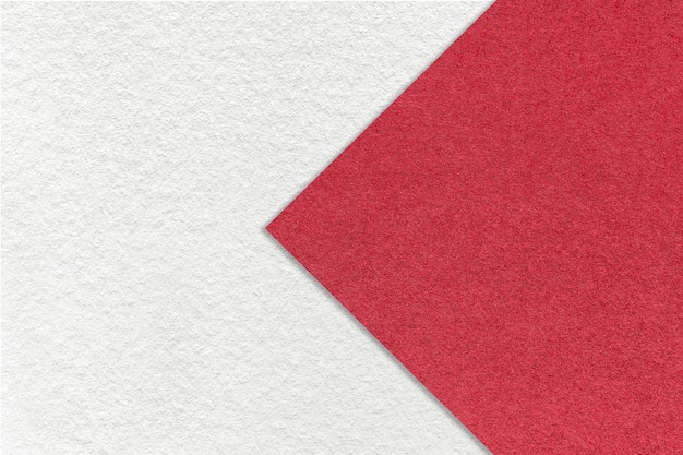 Texture of white paper background half two colors with red arrow sign macro Structure of craft ruby cardboard