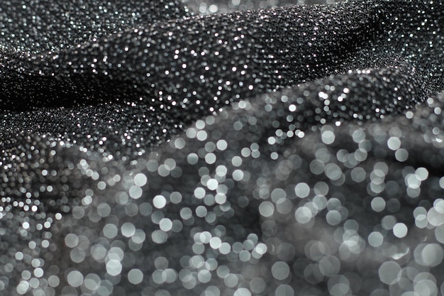 Texture with bokeh of shiny lurex fabric silver and black color