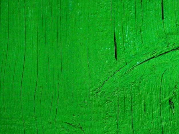 Texture of a wooden board painted in green Close up weather cracked surface