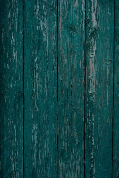 texture of a wooden fence painted green, peeling paint on an old fence