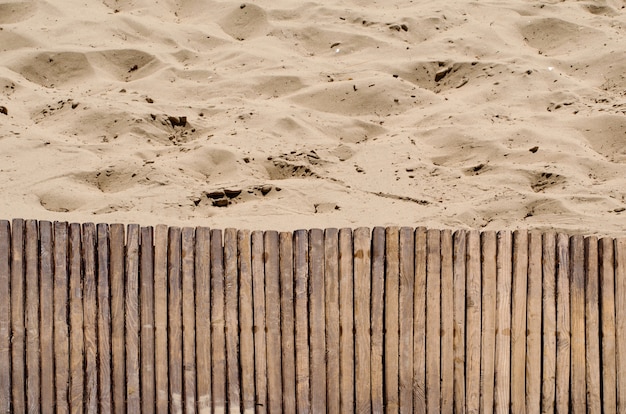 Texture of wooden path covered with white sand in the sea beach 