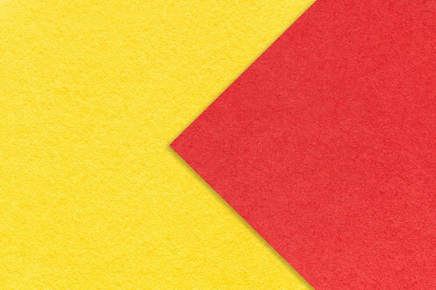 Texture of yellow paper background half two colors with red arrow macro Structure of craft cardboard