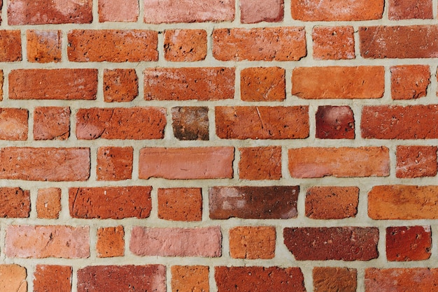 Textured red brick wall background or backdrop, rectangular red terracotta bricks laid out as pattern, architectural structure for old rough building. High quality photo