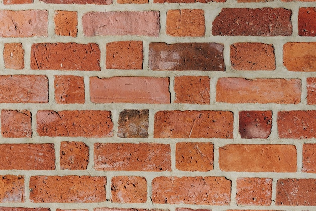 Textured red brick wall background or backdrop, rectangular red terracotta bricks laid out as pattern, architectural structure for old rough building. High quality photo