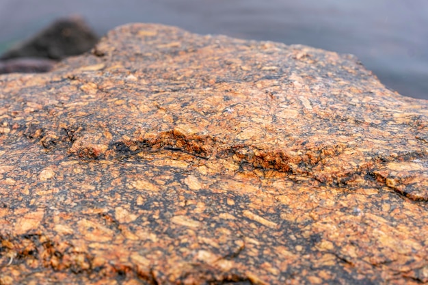 Textured surface of a huge natural brownred stone