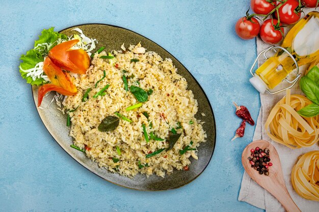 Photo thai basil leaf rice a plate of rice and vegetables with a spoon on a table