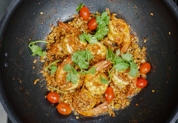 thai deep fried shrimps with garlics cherry tomatoes and corianders on a pan