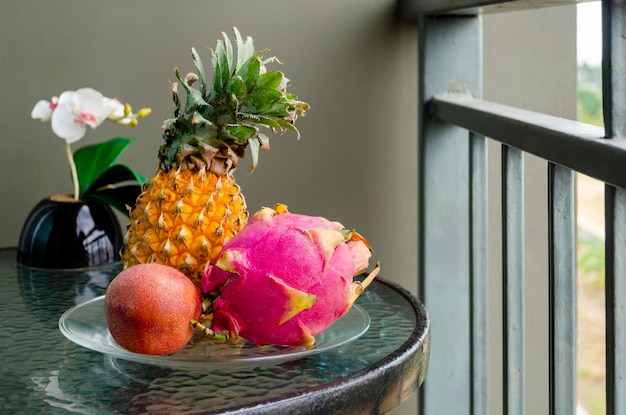 Thai exotic fruits pineapple dragonfruit passion fruit on a glass table