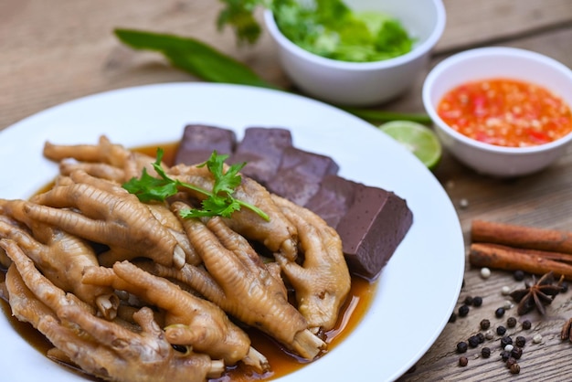 Thai food chicken feet soup stewed cooking chicken feet foot stew on white with herbs and spices ingredients with chilli lemon vegetable on wooden background Asian chinese food menu stew