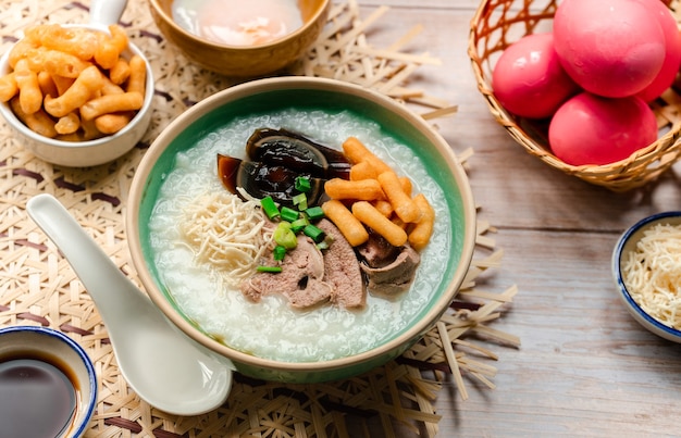 Thai food  Rice congee with sliced century egg sliced scalding liver and crispy deep fried dough stick topping with crispy noodle and soy sauce