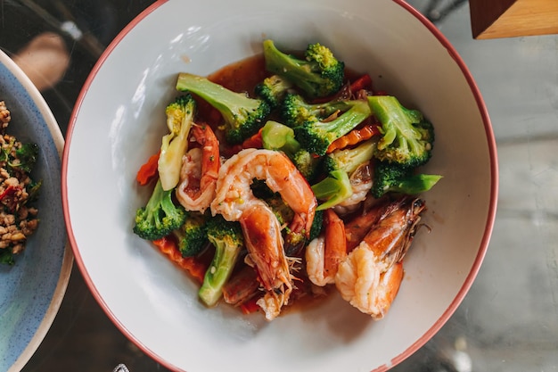 Thai food stir fried broccoli with shrimp on white dish