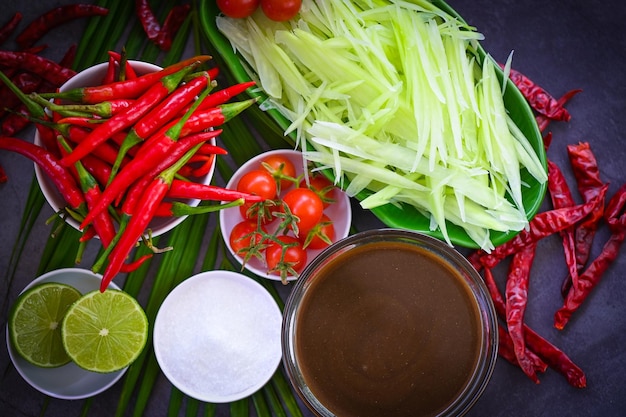 Thai food top view papaya salad spicy with herbs and spices condiments and ingredients with chili tomato lemon lime papaya Slice Thai Food