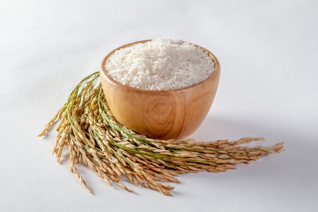 Thai jasmine rice in a wooden bowl and isolated rice on a white background