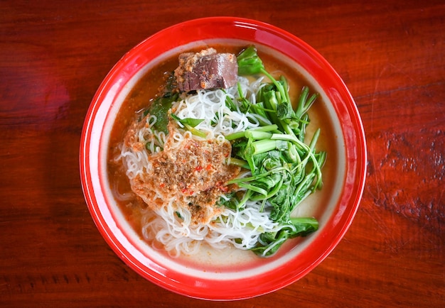 Thai rice noodle or rice vermicelli noodle and curry soup sauce on plate with vegetable yardlong Thai style food delicious