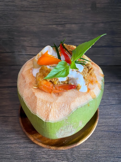 Thai Steamed Fish Curry or Ho Mok in the coconut on the table