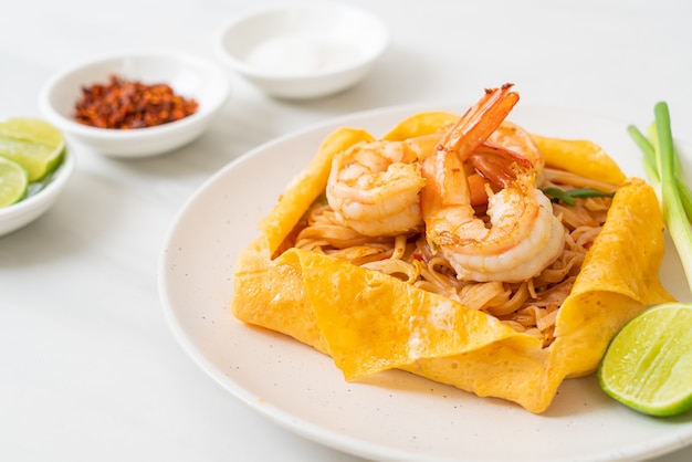 Thai stir fried noodles with shrimps and egg wrap (Pad Thai)