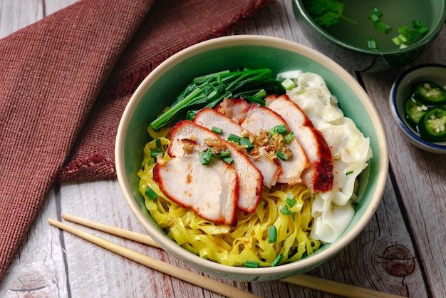 Thai street food - Egg noodle with barbecued red pork and wonton  serving with soup