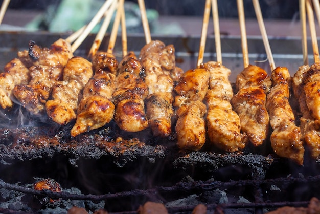 Thai street vendor sells grilled chicken meat at street food market in Thailand Close up