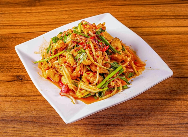 thai style crispy chicken salad isolated on wooden background top view