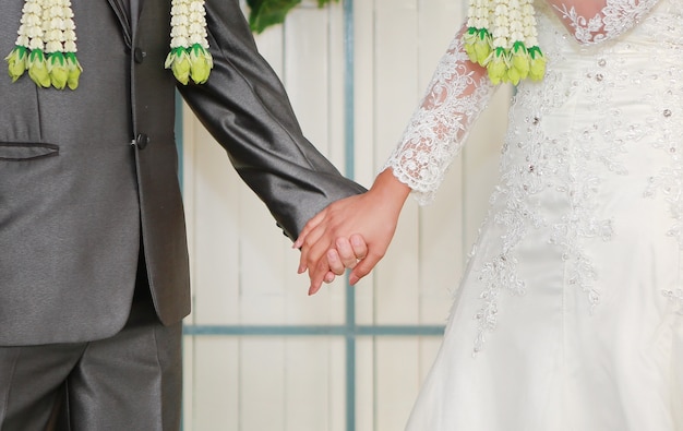 Thai wedding ceremony. Bride and groom hands.