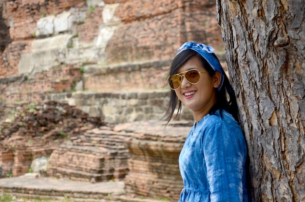 Thai women portrait with tree at ancient building at Wat Mahathat in Ayutthaya Thailand