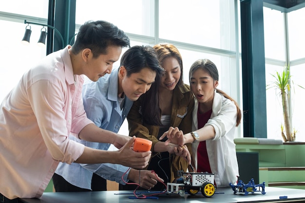 Thai young group discussion about their project robot in meeting room.Group of people check their modern for check system.