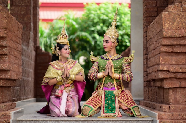 Thailand Dancing couple in masked Khon performances with ancient temple