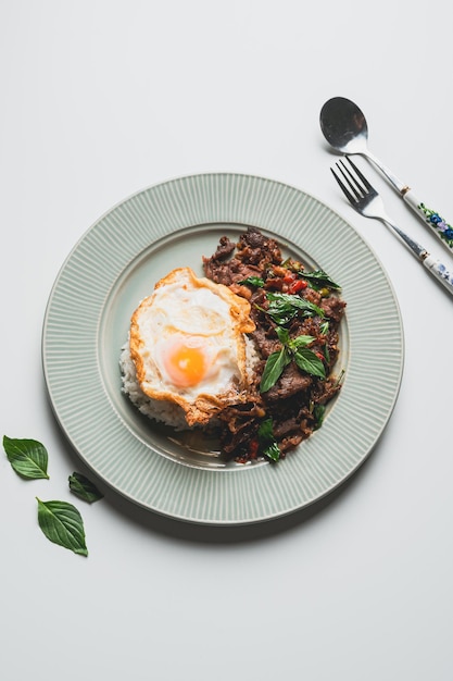 Thailand Food Stirfried beef and basil with fried egg on green plate Thai food conceptThai street food