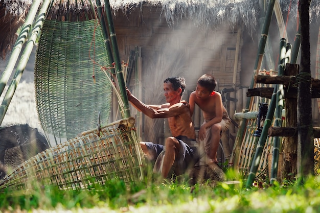 Thailand's father and son are making bamboo baskets or fishing gear by hand. Thailand's everyday life