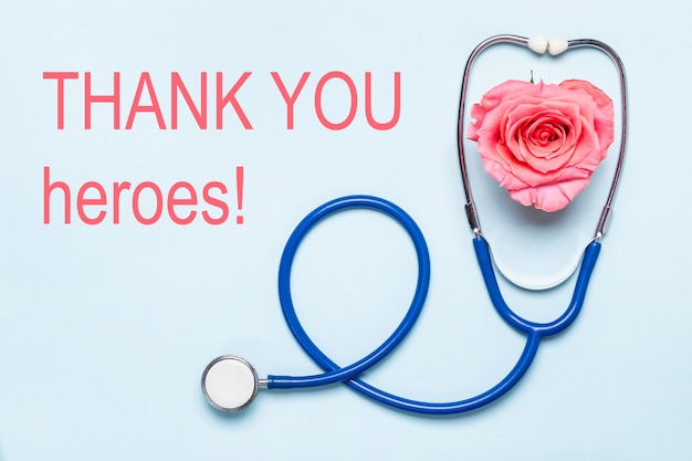 Photo thank you to healthcare heroes covid-19 pandemic poster. stethoscope and beautiful rose heart. thanks to doctors, nurses, hospital workers.