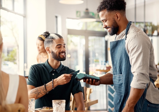 Thank you for your service Shot of a young man using a nfc machine to make a card payment at a restaurant