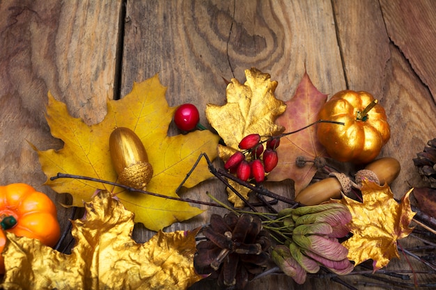 Photo thanksgiving background with golden pumpkin, acorn and  leavesdecoration