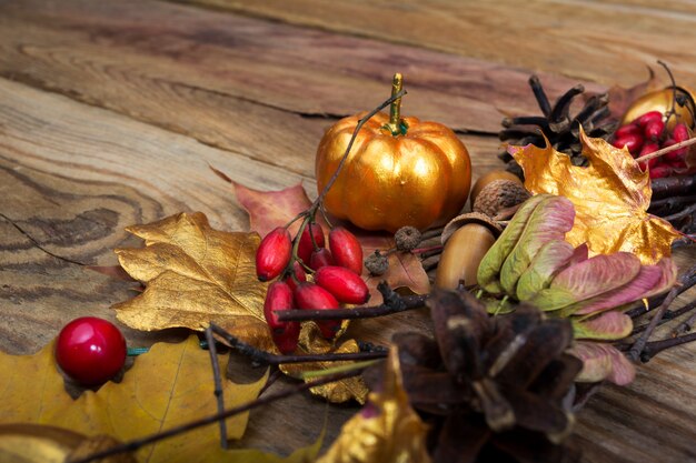 Thanksgiving background with golden pumpkin and maple leaves