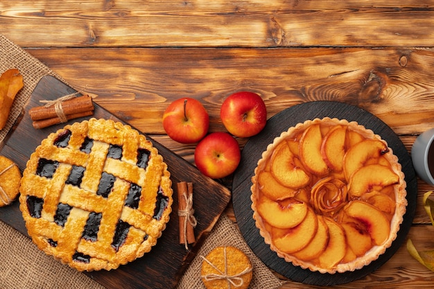 Thanksgiving berry and apple various pies on wooden surface, top view, copy space