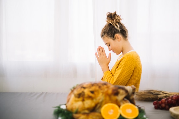 Thanksgiving dishes with side view of woman praying