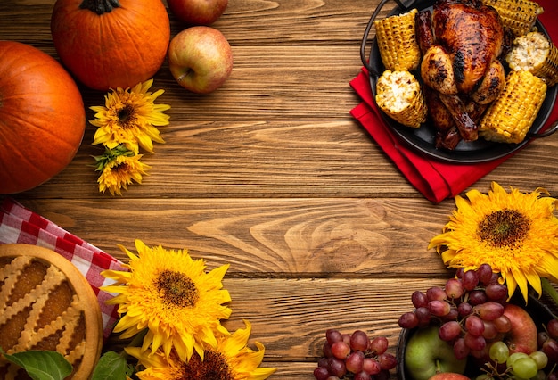 Thanksgiving festive table composition with roasted turkey, pumpkin pie, autumn fruit. Thanksgiving celebration dinner with traditional fall meals on rustic wooden table. Space for text, from above