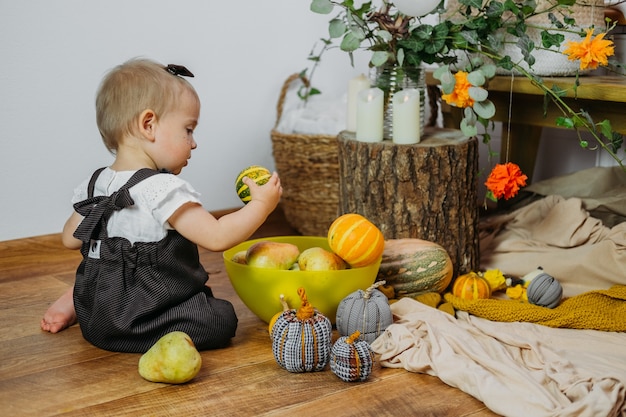 Thanksgiving greetings thanksgiving with family at home cute baby toddler girl play with pumpkins