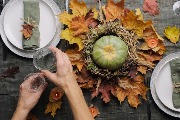 Thanksgiving table setting hands preparing table for autumnal feast