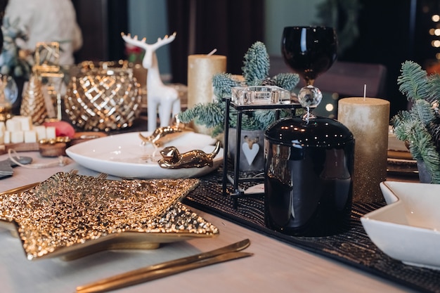 Thanksgiving table setting among white candles and cones