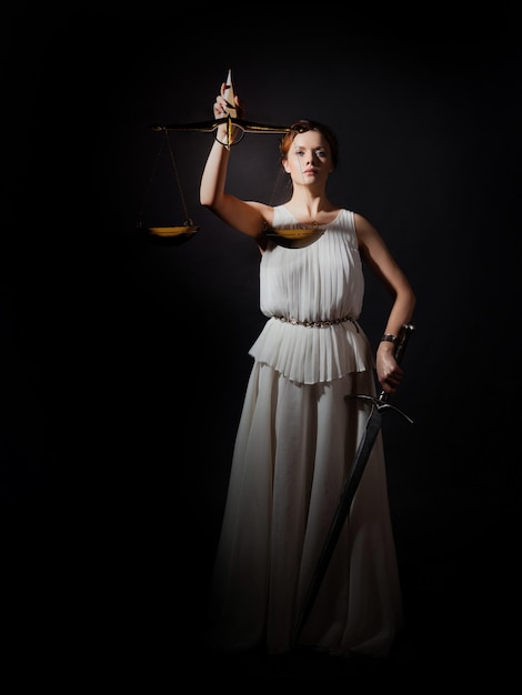 Themis the goddess of justice without a blindfold with scales and a sword in her hands fairness or i...